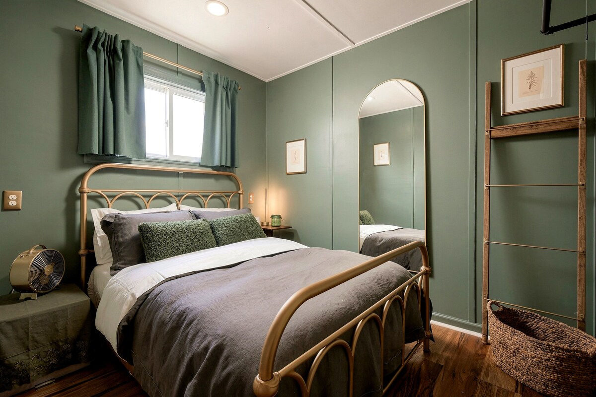 Second bedroom in deep green with brass bed