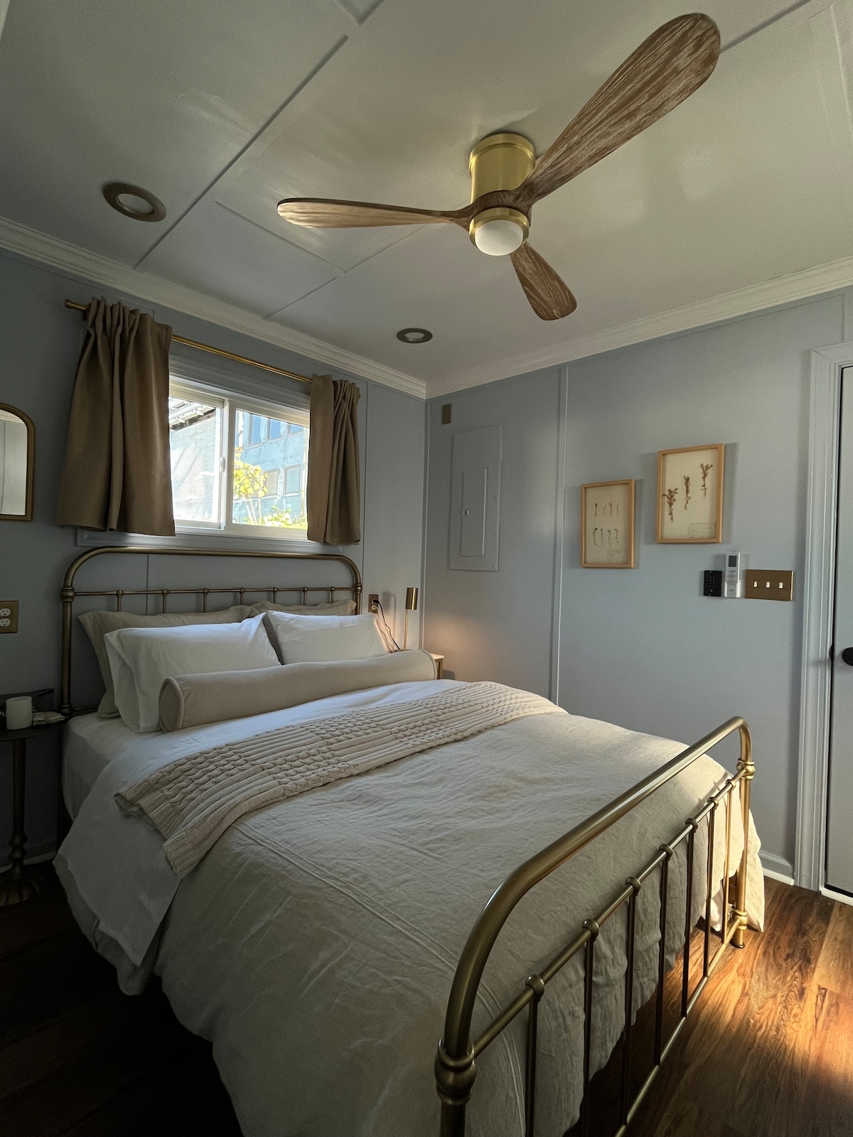 Bedroom with brass bed frame and ceiling fan