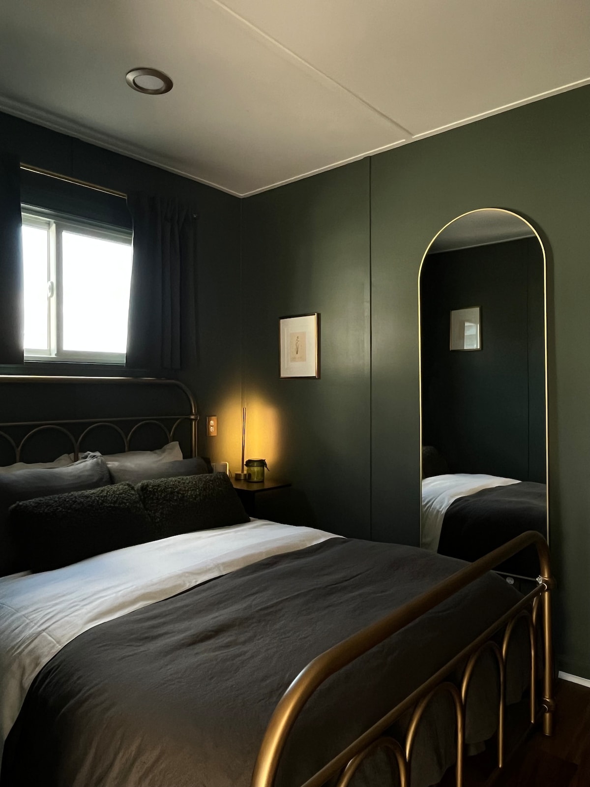 Second bedroom in deep green with brass bed