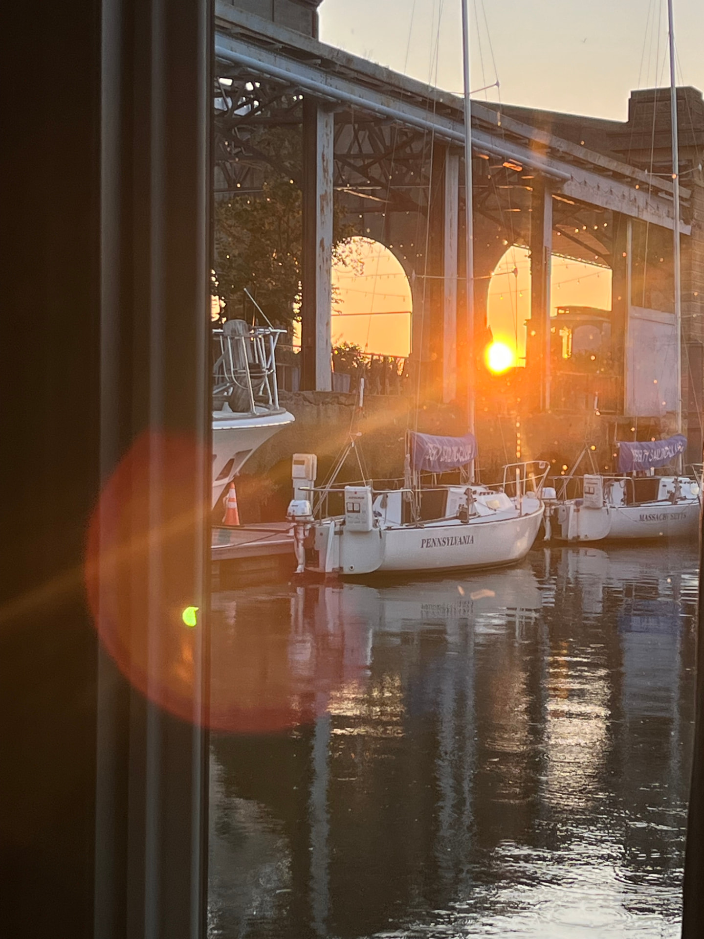Sailboats at the marina seen through the window at sunset